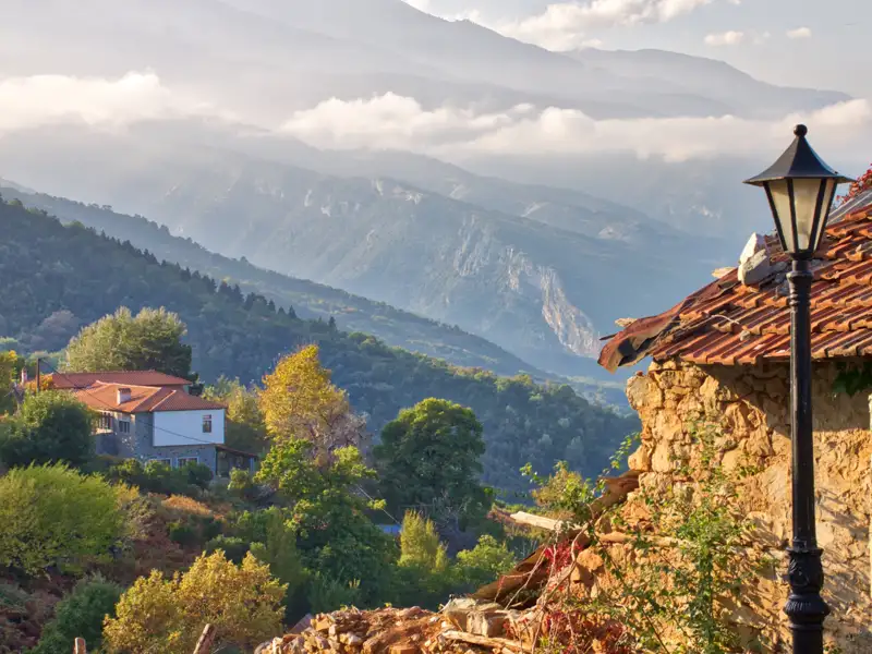 Traditionelles Haus und Laterne in einem Bergdorf mit Blick auf die umliegende Berglandschaft.
