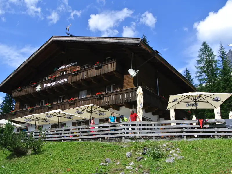 Dreischusterhütte mit Sonnenterrasse und Blick auf die Berge.