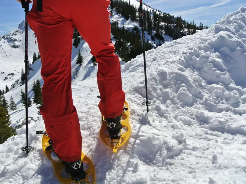 Nahaufnahme von Schneeschuhen beim Wandern im Schnee.