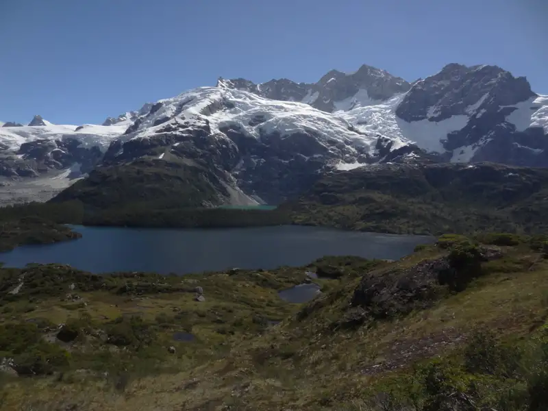 Panorama eines Bergsees mit schneebedeckten Bergen im Hintergrund.
