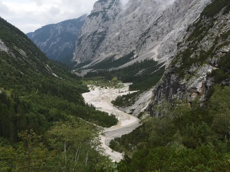 Blick auf ein Flusstal, umgeben von Bergen.