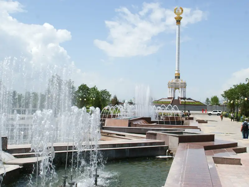 Denkmal mit goldener Spitze und Springbrunnen.