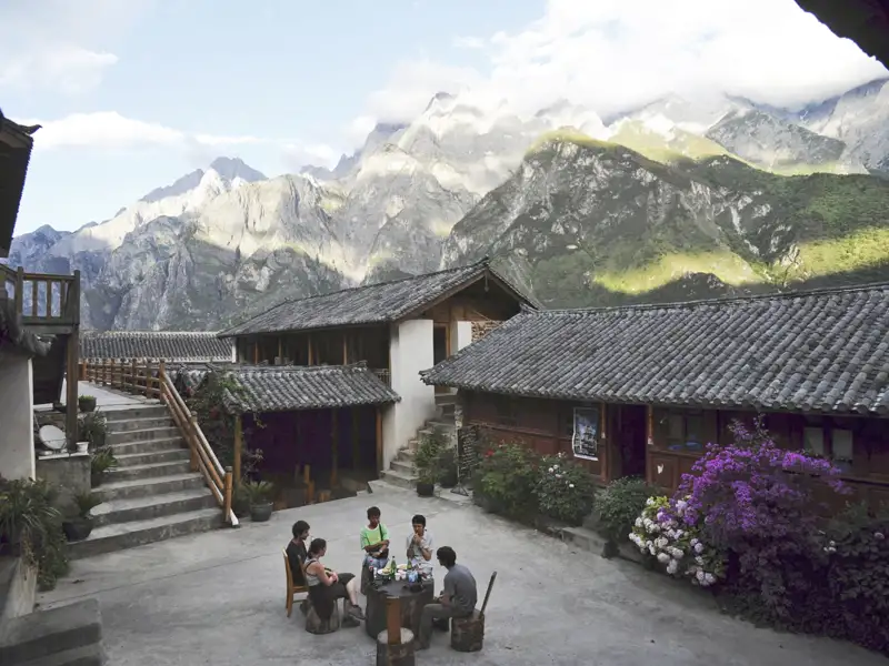 Innenhof einer Bergunterkunft mit Reisenden, die sich entspannen.