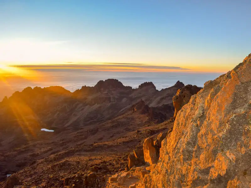 Sonnenaufgang über den Bergen mit Blick auf ein Wolkenmeer.