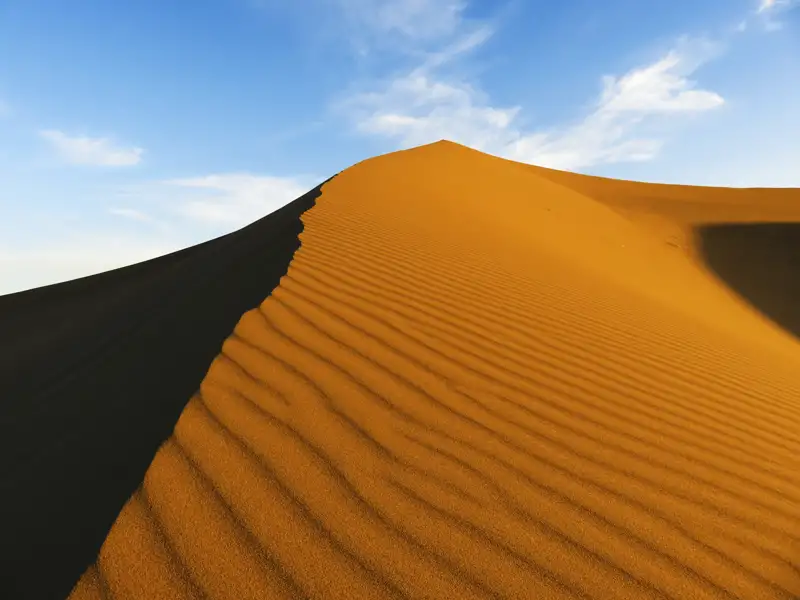 Nahaufnahme einer Sanddüne mit sichtbaren Sandrippeln.