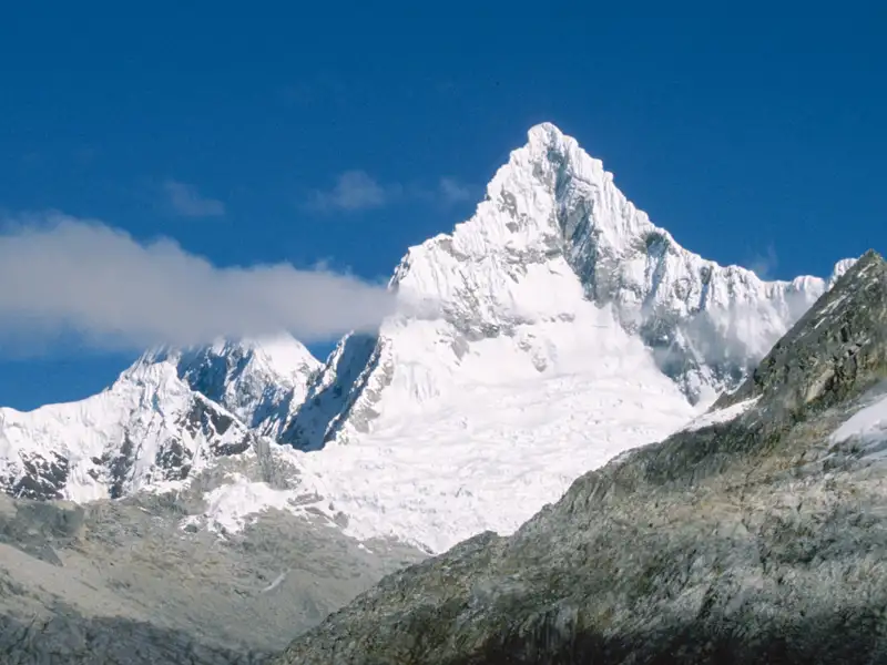 Panorama einer schneebedeckten Bergkette unter blauem Himmel.
