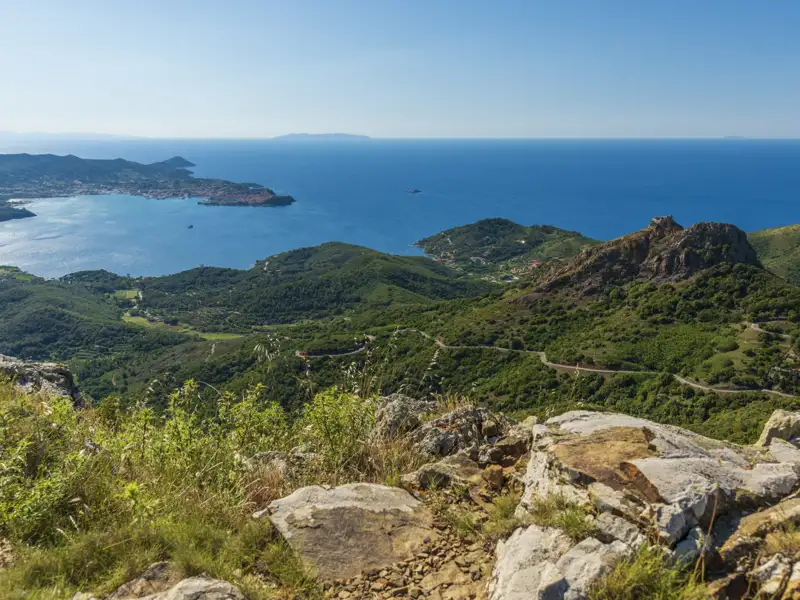 Aussicht von einem erhöhten Standpunkt auf die Küstenlandschaft und das Meer.