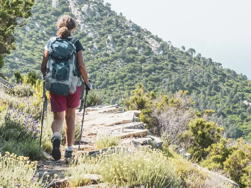 Wanderin auf einem steinigen Bergpfad.