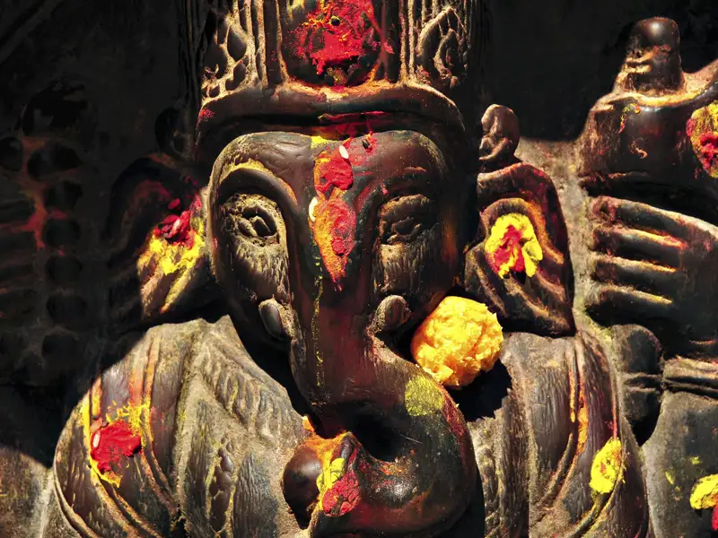 Detaillierte Ansicht einer Ganesha-Statue mit Farbspritzern.