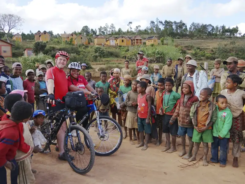 Zwei Radreisende treffen auf Dorfbewohner während ihrer Reise.