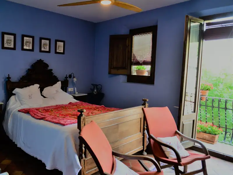 Schlafzimmer mit Doppelbett und Balkon.