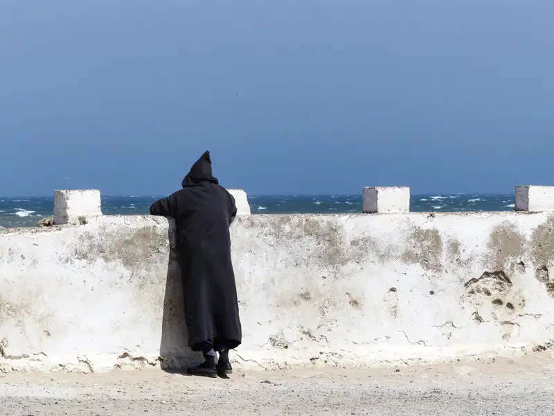 Person in traditioneller Kleidung am Meer