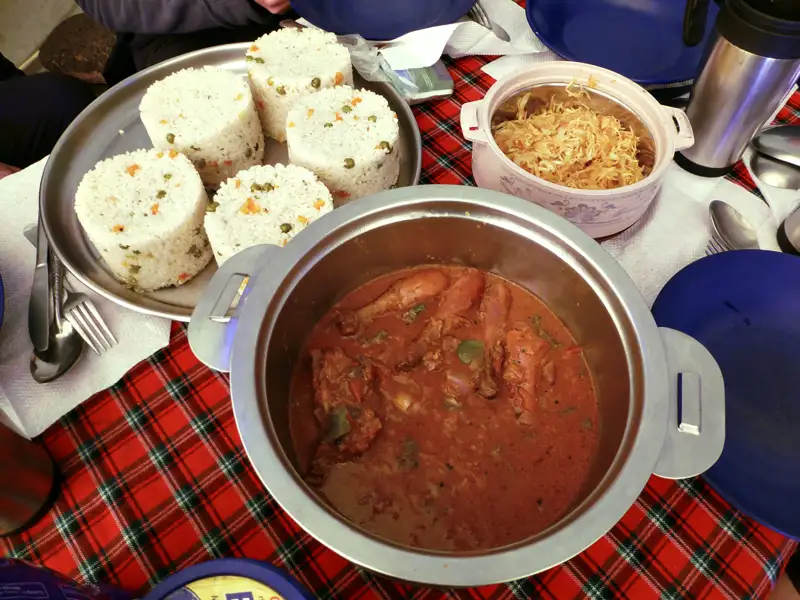 Hühnergericht mit Reis und Gemüse, serviert während der Reise.