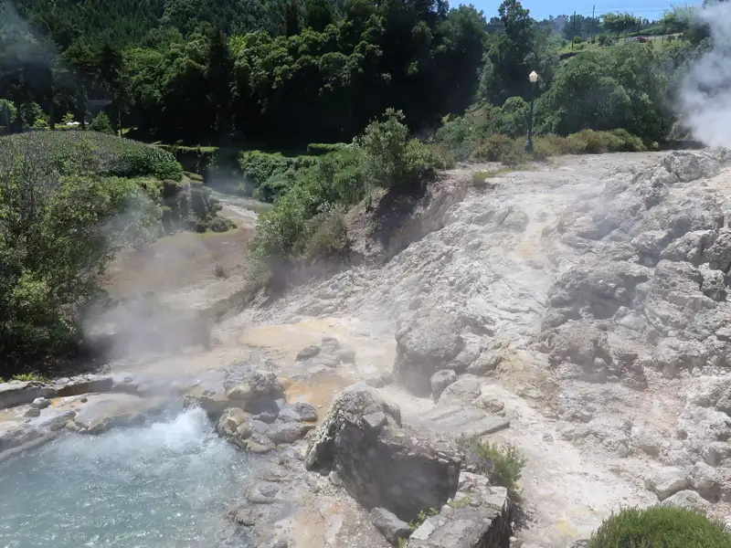 Dampfende heiße Quellen und mineralische Ablagerungen, die die geothermische Aktivität der Region zeigen.