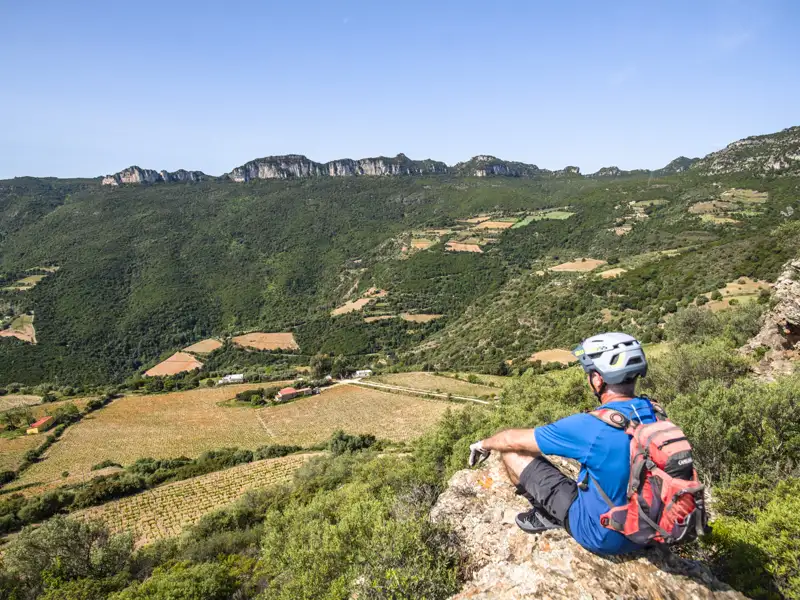 Radfahrer pausiert und genießt den Ausblick auf das Tal während seiner Radtour.