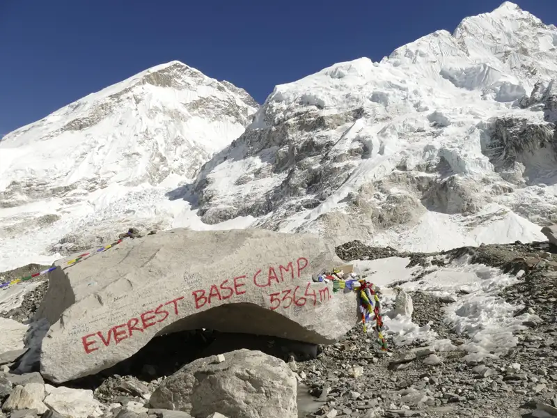 Everest Base Camp Markierungsstein mit Mount Everest im Hintergrund.