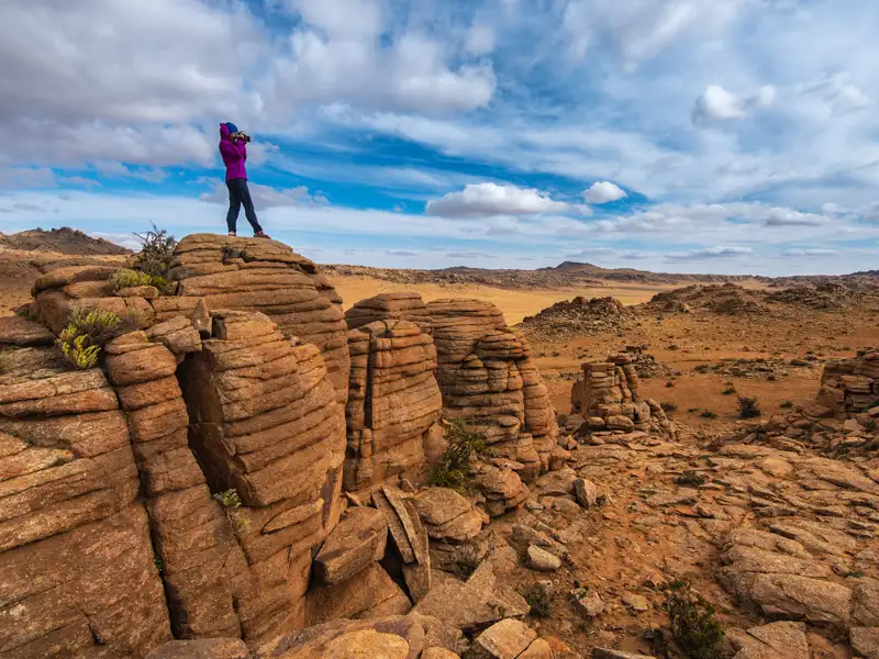 Reisender betrachtet die Landschaft von einem Felsvorsprung aus.