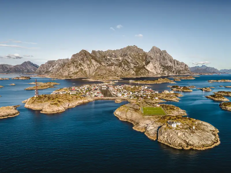 Luftbild einer Inselgruppe mit Dorf und Fußballfeld.