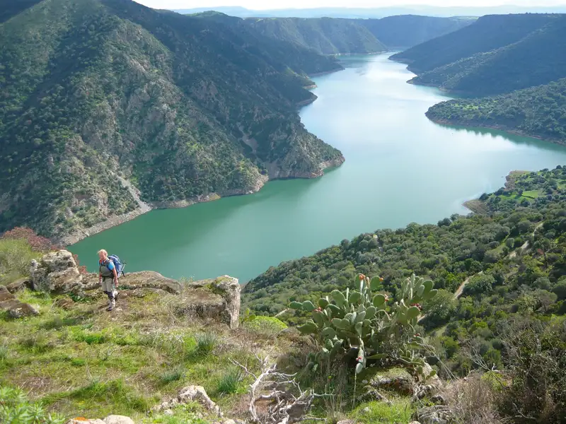 Wanderer auf einem Aussichtspunkt mit Blick auf den Fluss und die umliegende Landschaft.