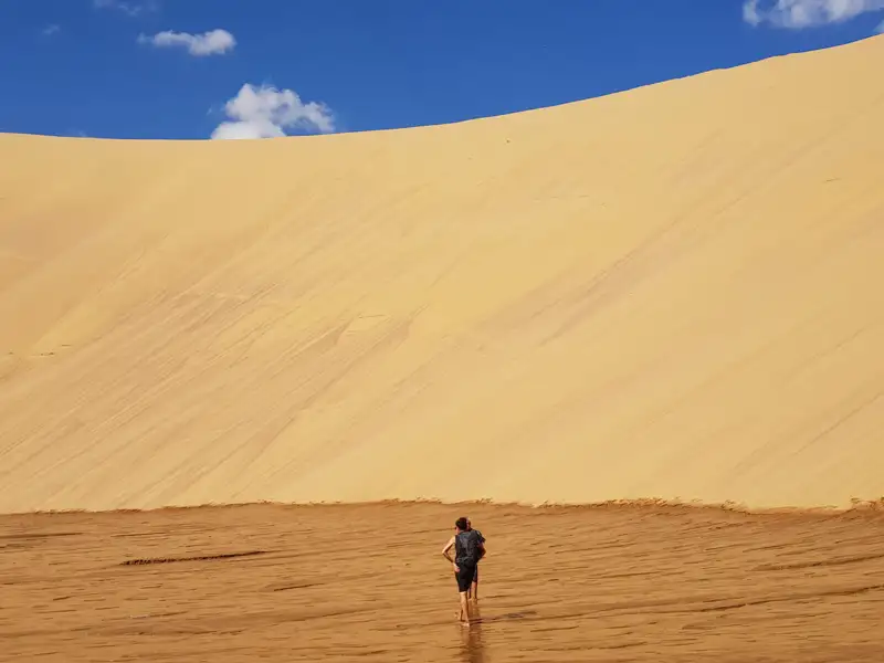 Reisender am Fuß einer Sanddüne.
