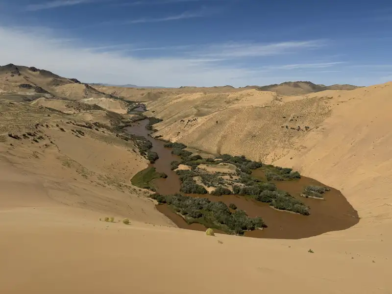 Flusslandschaft inmitten von Sanddünen.