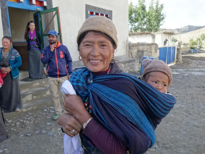 Frau mit Kind im Tragetuch.