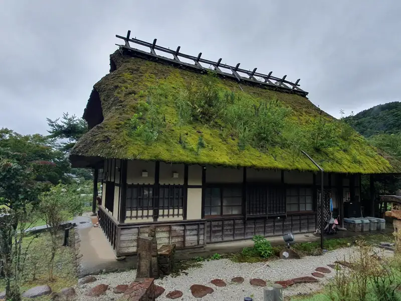 Traditionelles japanisches Haus mit einem Dach aus Moos und Gras.