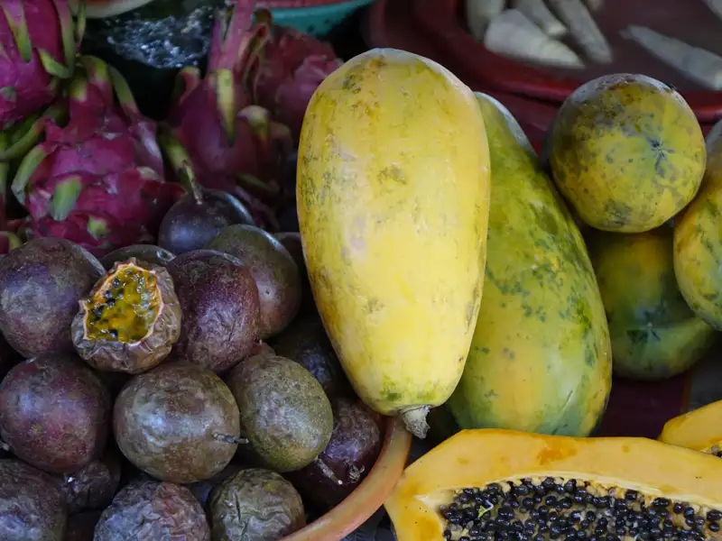 Auslage mit frischen Papayas, Passionsfrüchten und Drachenfrüchten auf einem lokalen Markt.