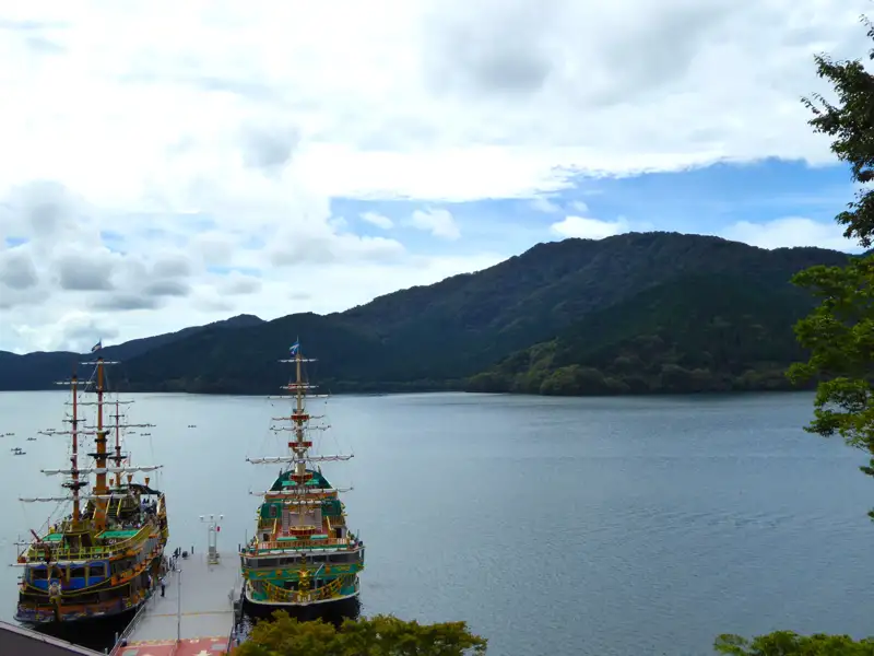 Zwei Piratenschiffe am Steg mit Blick auf den See und die Berge.