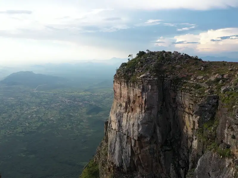 Steile Felsklippe mit Blick auf eine weite Landschaft.