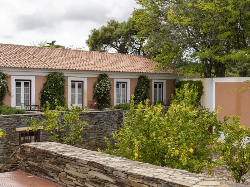 Innenhof des Hotels mit blühenden Pflanzen und Terrassenzugang von den Zimmern.