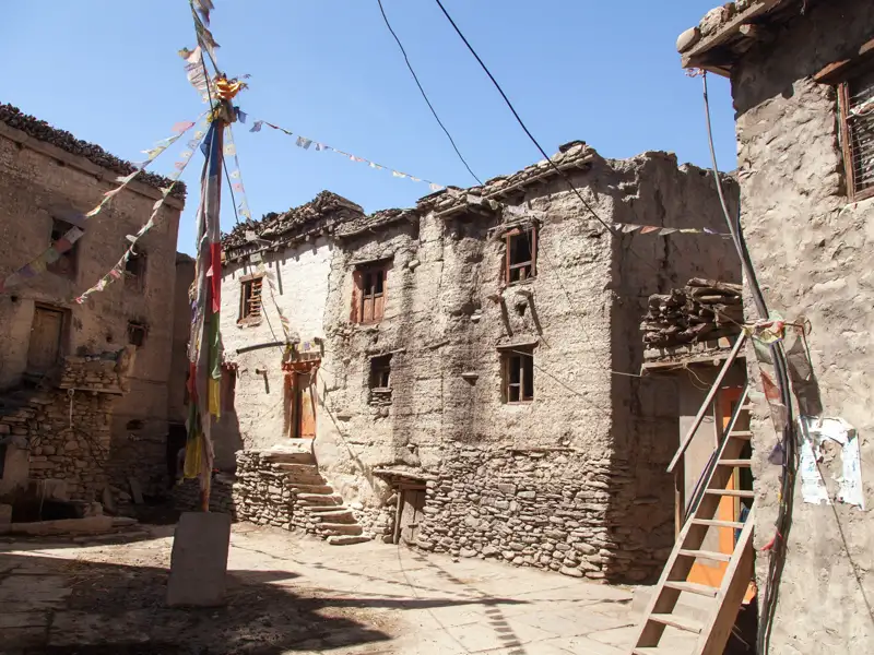 Traditionelle Dorfarchitektur mit Gebetsfahnen.
