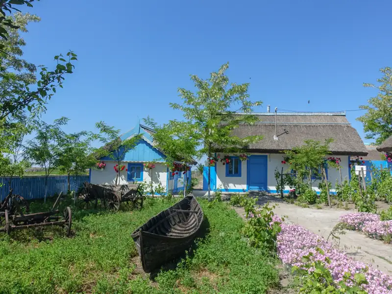 Traditionelle Häuser mit blau-weißer Fassade und Reetdach, typisch für die Region.