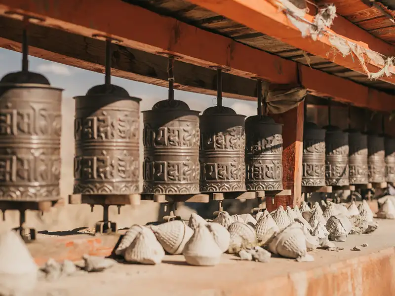 Tibetische Gebetsmühlen und Opfergaben.