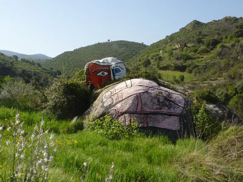 Bemalter Felsen in einer Hügellandschaft.