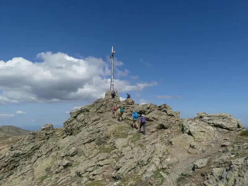 Wanderer auf dem Weg zum Gipfelkreuz.