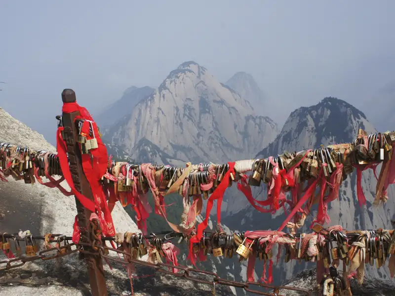 Liebesschlösser und Bänder an einem Bergpfad.