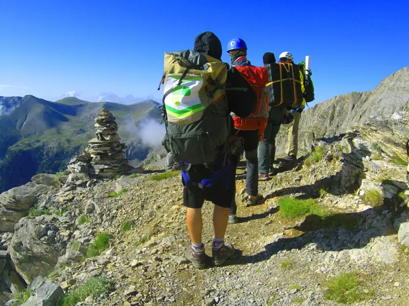 Wanderer mit Rucksäcken auf einem Bergpfad in den Bergen.