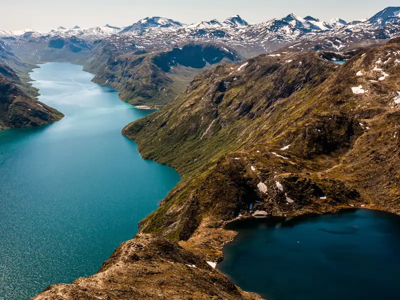 Panoramablick auf einen Fjord und schneebedeckte Berge.