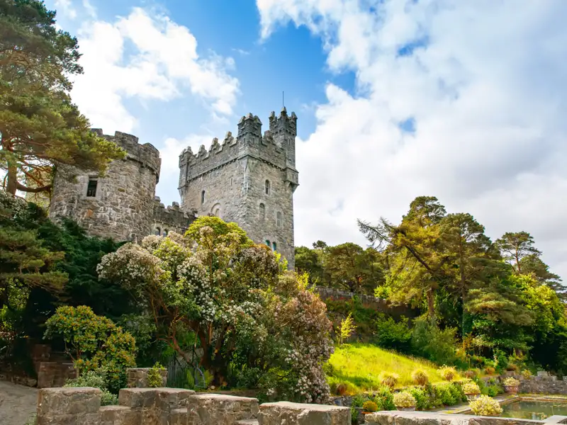 Alte Steinburg inmitten einer Gartenanlage.