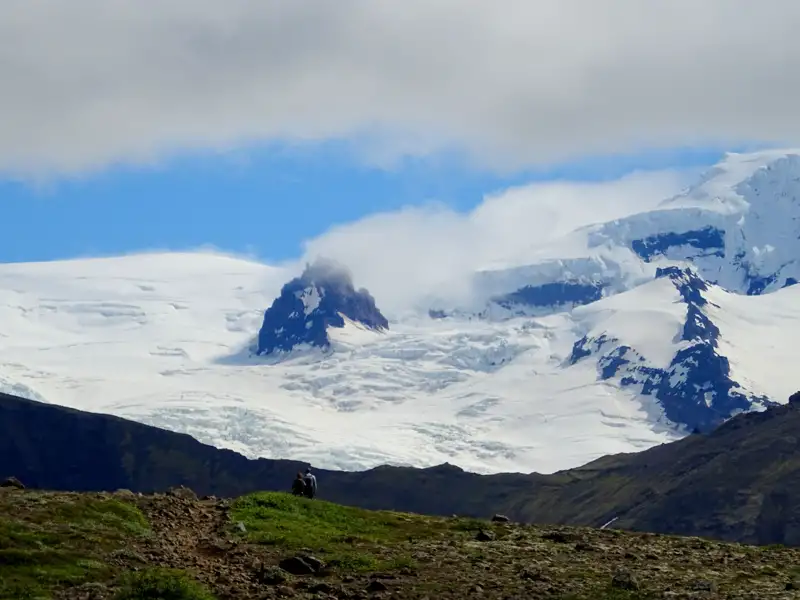 Gletscher mit dunklem Felsvorsprung und Wolken.
