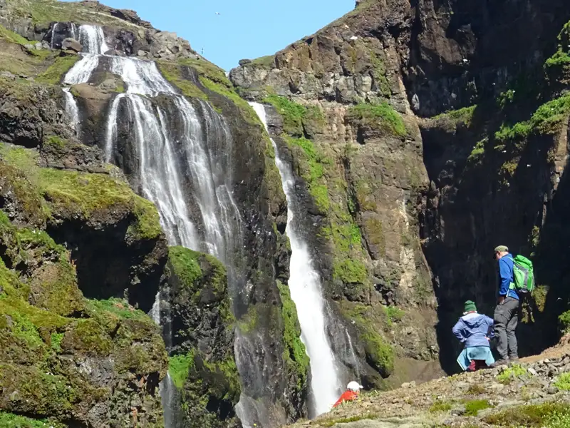 Wanderer beobachten einen Wasserfall.