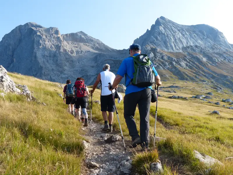 Wanderer auf einem Bergpfad mit Blick auf die Berge.