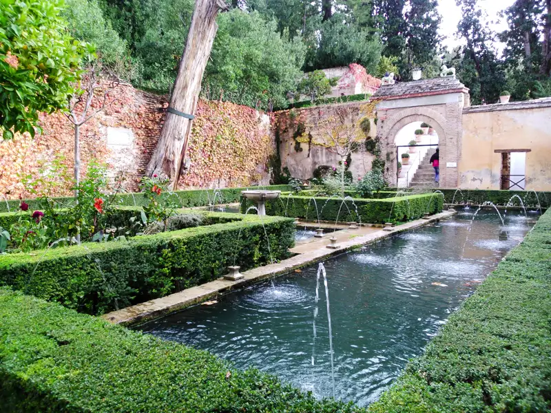 Wasserspiele und Hecken in einem Garten.