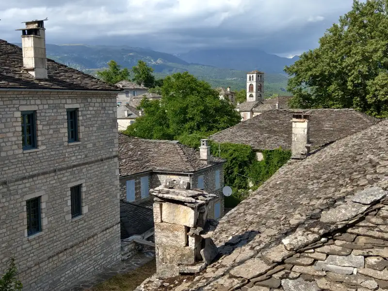 Steindächer und Kirchturm eines Bergdorfes.