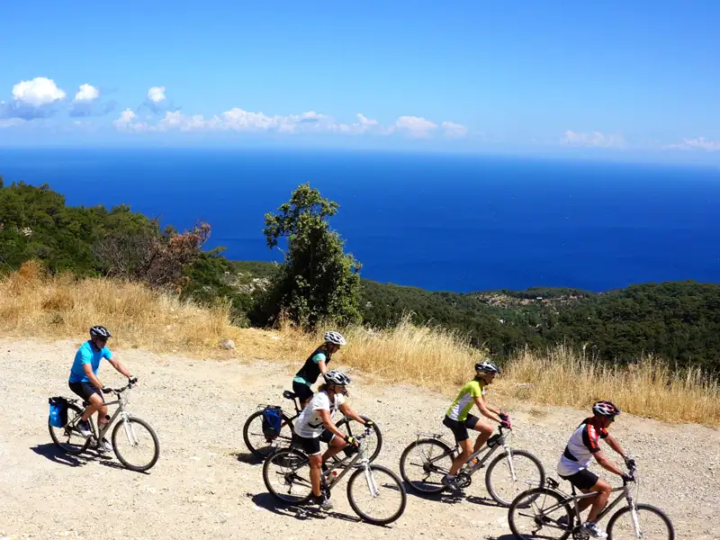 Radfahrer auf einer Küstenstraße mit Blick auf das Meer.