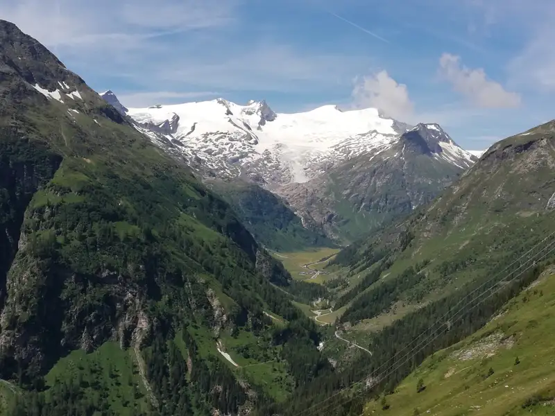 Schneebedecktes Gebirge und grünes Tal