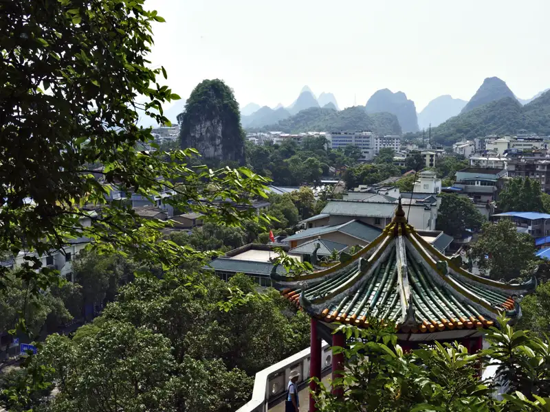 Panoramablick auf die Karstberge und einen traditionellen Pavillon.