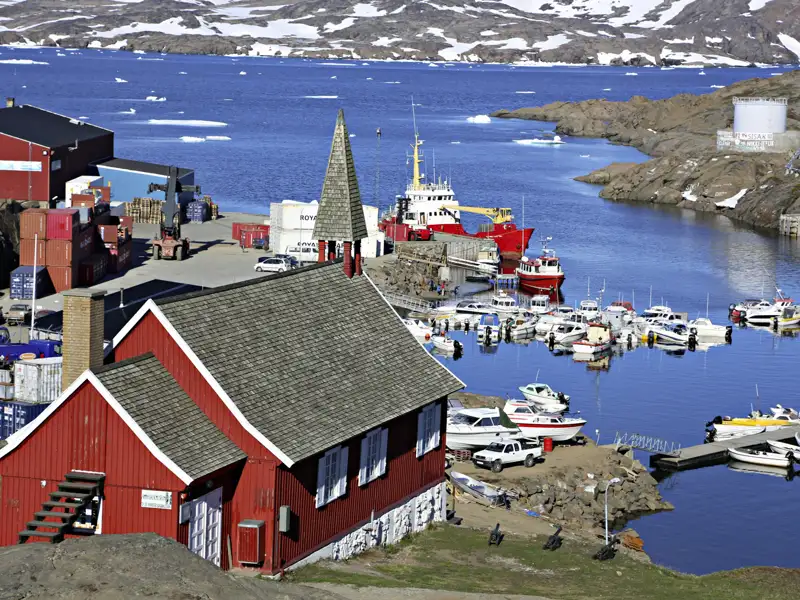 Hafen mit Booten und rotem Gebäude.