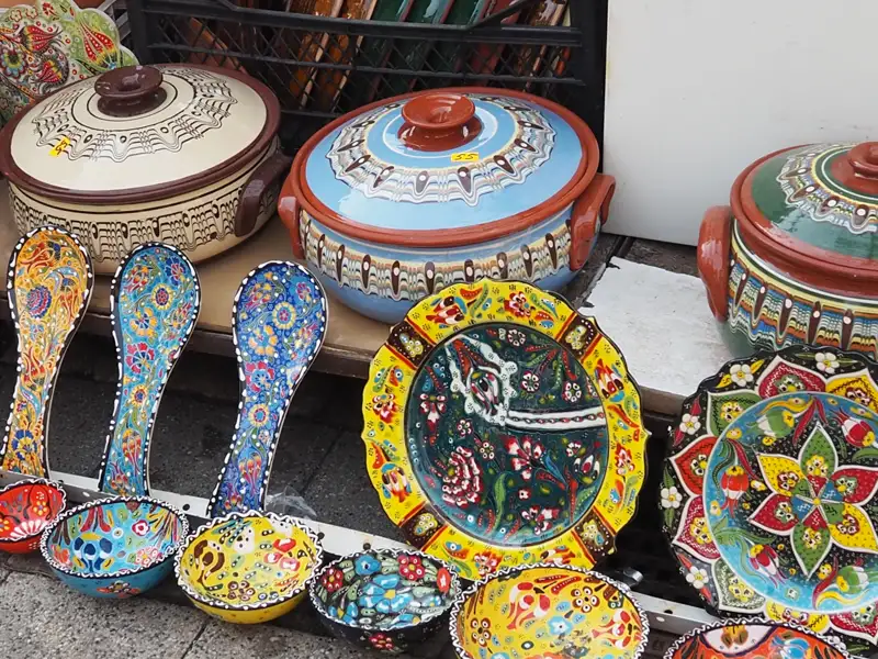 Handgefertigte Keramik: Ausstellung von bemalten Töpfen, Tellern und Löffeln mit traditionellen Mustern.